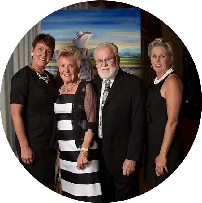 A group of people standing in front of a painting.